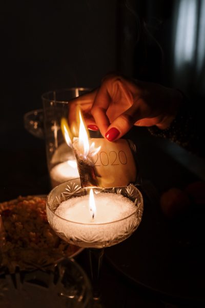 An intimate candlelight dinner scene with a symbolic burning of 2020 in a cozy home setting.